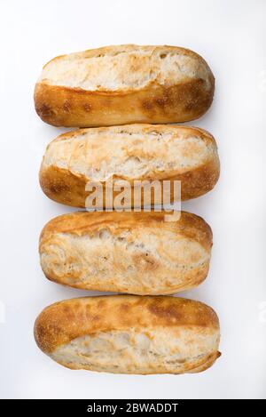 French bread rolls in a row isolated on light background. Stock Photo