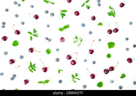 Cherry and blueberries with mint on white background. Top view. Flat lay Stock Photo