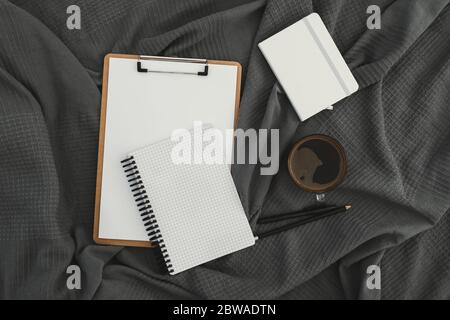 Mug of coffee with clipboard, diary and pen on gray. Flat lay, top view. Stay at home. Stock Photo