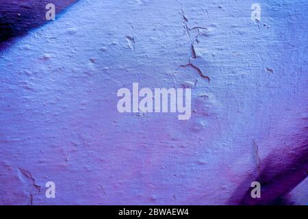 Blue and violet abstract paint on a white cracked wall. Close-up of a graffiti texture. Street art background. Stock Photo
