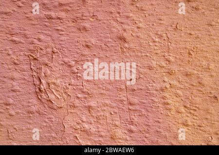 Salmon color gradient paint on a stucco scratched wall. Close-up of a graffiti texture. Street art background. Stock Photo