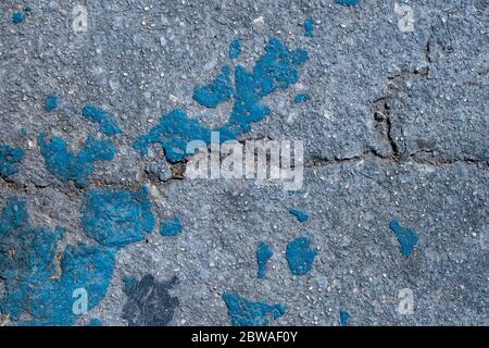 Asphalt road texture with worn blue paint. Close-up. Top view. Stock Photo