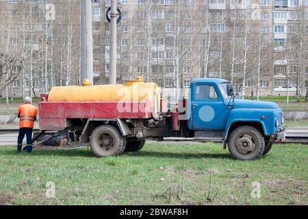 Cleaning the sewage well with an old truck. Conception clean city. Stock Photo