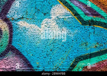 Geometric graffiti close-up on concrete block wall texture. Street art background. Light blue, multicolored. Stock Photo