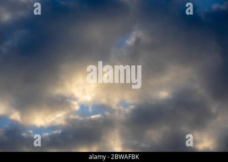 Gray clouds covering the sun during sunset. Sky background. Stock Photo