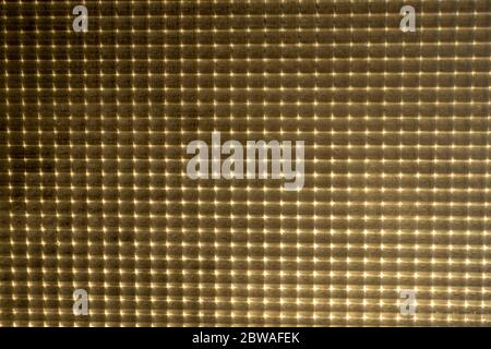 Old illuminated glass pattern texture. Sunlight through a translucent window with relief. Stock Photo