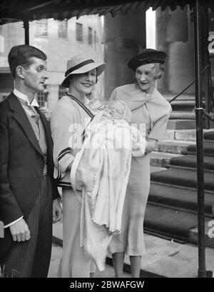 Mr and Mrs Edgar Howard Tripp and their infant daughter after the baby ' s christening at All Souls Church , Langham Place , London . On the right is June , Lady Inverclyde ( Mr Edgar Tripp ' s actress sister ) . 6 June 1935 Stock Photo