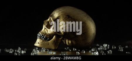 Broken glass pieces and golden skull on black background. 3D illustration Stock Photo