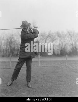 Golf at Northwood House of Commons versus Sandy Lodge CLub Dr Macnamara driving 28 February 1920 Stock Photo