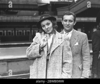 Film stars ' Doubles ' arrive at Paddington Station , London . Miss Ezelle Poule a double for actress , Zasu Pitts and Earl Haddon a double for crooner Bing Crosby . 1938 Stock Photo