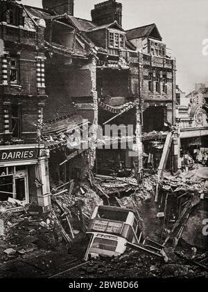 Following an air raid on London during the Blitz German bombing campaign against the United Kingdom in 1940 and 1941, during the Second World War, a bus in a huge bomb crater. Stock Photo