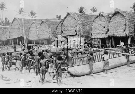 Great Island to be explored British Pacific Science Expedition Sails for Papua The dug outs are seen in position and the natives are on the point of putting the cross poles in place 14 December 1922 Stock Photo