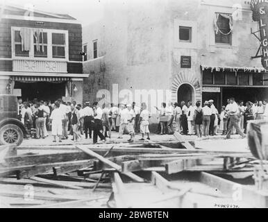 Food distribution after disastrous hurricane and flood in Florida . Residents of Miami in debris littered streets standing in line waiting for tickets entitling them to their rations of food . 2 October 1926 Stock Photo