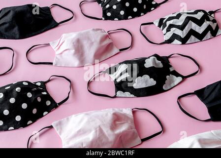 Handmade face protective masks on pink flat lay background. Reusable ecological face masks against coronavirus, covid-19 or flu. Pattern of medical ma Stock Photo