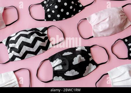 Handmade face protective masks on pink flat lay background. Reusable ecological face masks against coronavirus, covid-19 or flu. Pattern of medical ma Stock Photo