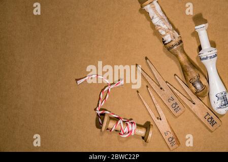 Vintage wooden tools, sewing accessories, thread and decorative objects on brown cardboard. Concept of sewing hobby Stock Photo