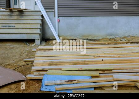 House under construction of stack unloading wooden beams on construction building from beam construction materials Stock Photo