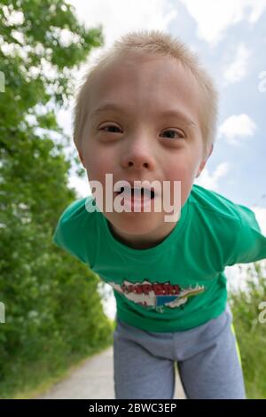 Close-up portrait of boy with Down syndrome on in the park. Stock Photo