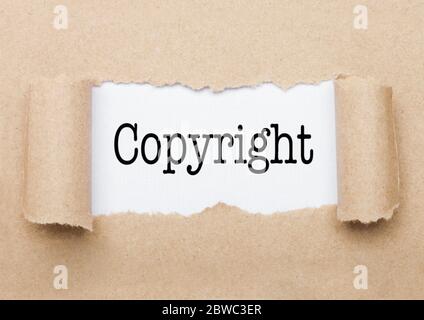 Copyright concept text appearing behind torn brown paper envelope Stock Photo