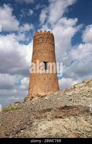 One of many old watchtowers on prominent location on the hills surrounding Al Mudairib in Oman Stock Photo