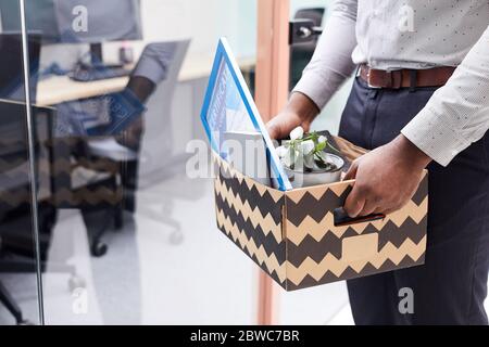 Close up of unrecognizable African-American man holding box of personal belongings after quitting job, copy space Stock Photo