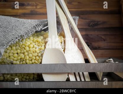 Macaroni in transparent packaging on the kitchen table. Stock Photo
