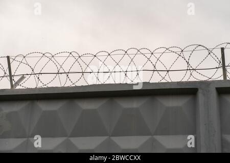 gray concrete wall with barbed wire. Gray background Stock Photo