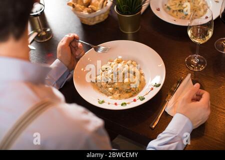 Overhead view at man eating gnocchi in the restaurant Stock Photo