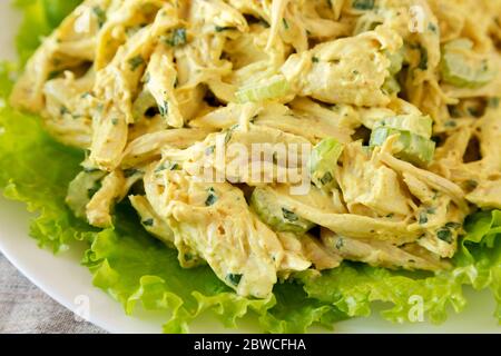 Homemade Coronation Chicken Salad on a white plate, low angle view. Close-up. Stock Photo