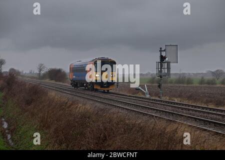 East Midlands trains class 153 train 153357 passing the mechanical  semaphore signals at Roxton Sidings (Lincs) Stock Photo