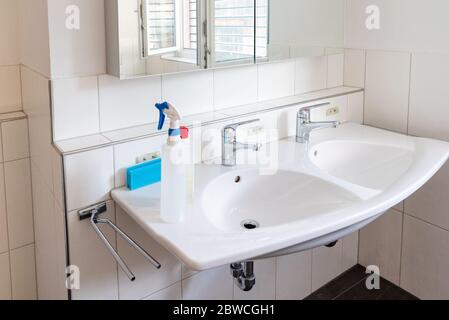 Interior view of a very clean and modern bathroom in a residence with cleaning equipment on the bathroom sink Stock Photo