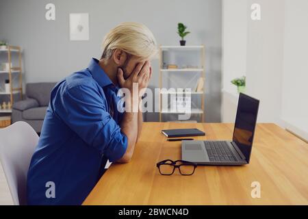 Tired male freelancer businessman in home office Stock Photo