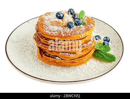 Stack of pumpkin pancakes with blueberries and mint on white plate. Isolated on white Stock Photo