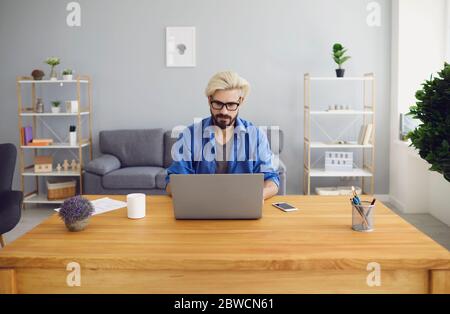 Concentrated businessman working online on laptop in home office Stock Photo