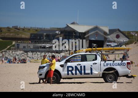 Newquay Fistral Beach Cornwall. - Return of lifeguards 2020 post covid lockdown, Lifeguards have returned to a small number of beaches on the north Cornish coast - Pictured here wearing suitable PPE and face masks to comply with the Covid safe message. Stock Photo