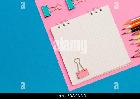 Stationery. School and office supplies on a blue and pink colored background. Selective focus.Advertising space Stock Photo