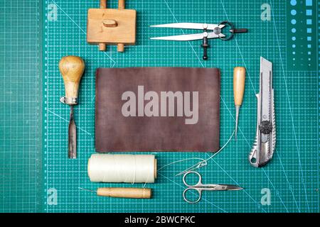 Top view of Leather work tools and a piece of leather. Stock Photo