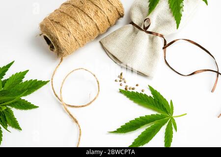 Hemp thread, medical marijuana leaves and seeds, close-up. Using cannabis in fabric production and industry Stock Photo