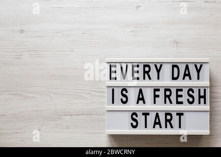 'Every day is a fresh start' words on a lightbox on a white wooden background, top view. Overhead, from above, flat lay. Copy space. Stock Photo