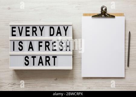 'Every day is a fresh start' words on a lightbox on a white wooden surface, top view. Overhead, from above, flat lay. Stock Photo