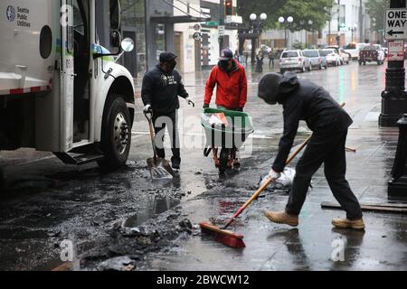 Seattle, WA, USA. 31st May, 2020. People clean up debris from a car that had been set on fire the previous night during a riot on May 31, 2020 in Seattle, Washington. Protests erupted nationwide over the death of George Floyd who died while in the custody of a policeman who knelt on his neck in Minneapolis. Credit: Karen Ducey/ZUMA Wire/Alamy Live News Stock Photo