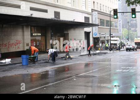 Seattle, WA, USA. 31st May, 2020. People clean up damage to storefronts and streets early in the morning after rioters, expressing outrage over the death of George Floyd, looted stores and burned cars the previous night on May 31, 2020 in Seattle, Washington. Protests erupted nationwide after Floyd died while in the custody of a policeman who knelt on his neck in Minneapolis. Credit: Karen Ducey/ZUMA Wire/Alamy Live News Stock Photo