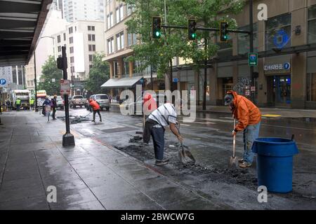 Seattle, WA, USA. 31st May, 2020. People clean up damage to storefronts and streets early in the morning after rioters, expressing outrage over the death of George Floyd, looted stores and burned cars the previous night on May 31, 2020 in Seattle, Washington. Protests erupted nationwide after Floyd died while in the custody of a policeman who knelt on his neck in Minneapolis. Credit: Karen Ducey/ZUMA Wire/Alamy Live News Stock Photo