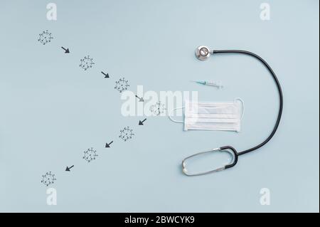 Covid 19 prevention and protection conceptual image - Coronavirus molecules shield made of stethoscope, vaccine and medical protective mask. Stock Photo