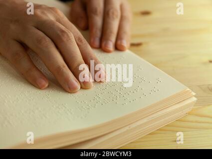 Braille reading. Blind woman reads a book in braille Stock Photo