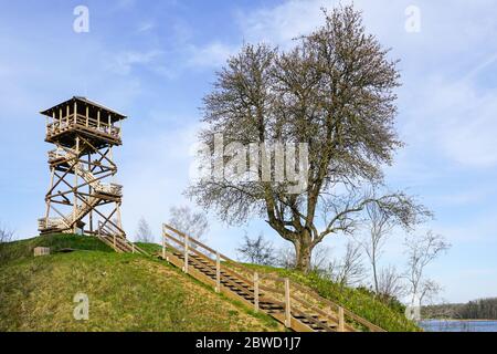 a wooden bird watching tower on top of a hill by the lake 2bwd1j7