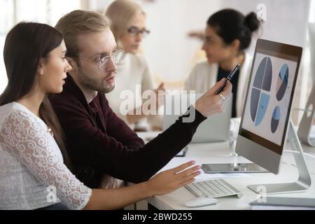 Motivated coworkers working on presentation in office. Stock Photo
