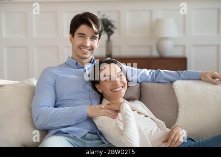 Portrait of happy young couple relaxing on couch Stock Photo
