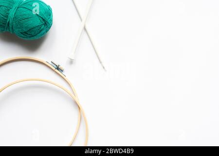 top view of green wool yarn, knitting looms and knitting needles on white background Stock Photo