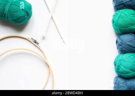 top view of blue and green wool yarn, knitting looms and knitting needles on white background Stock Photo